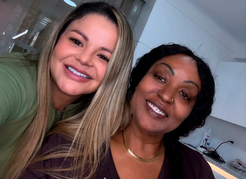 Dr. Yazmin Escudero with a dental tourism patient showing her new porcelain veneers in Medellin, Colombia.